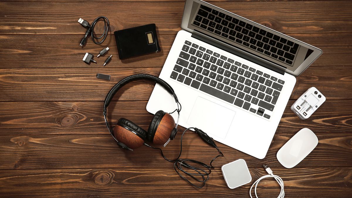 "Minimalist desk with laptop and accessories like mouse, keyboard, hub, headphones, and SSD."